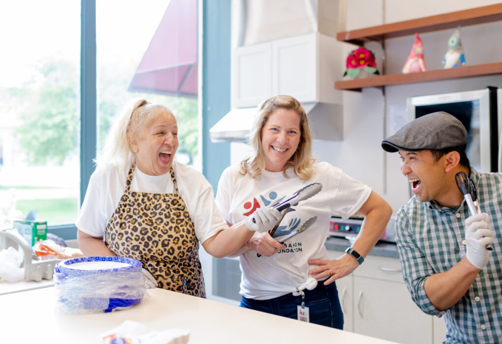 Three people fooling around in a bright room